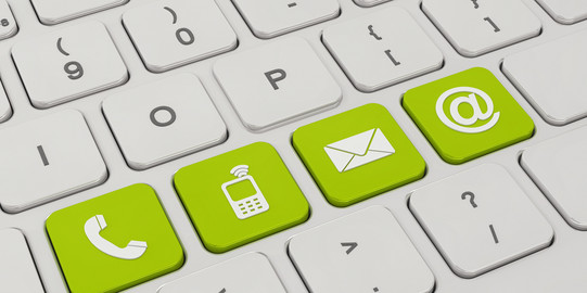 Kontakt Auf einer weißen Tastatur sind vier Tasten grün eingefärbt. Darauf zu sehen sind Symbole für ein Telefon, ein Mobiltelefon, ein Briefumschlag und ein "at"-Zeichen.